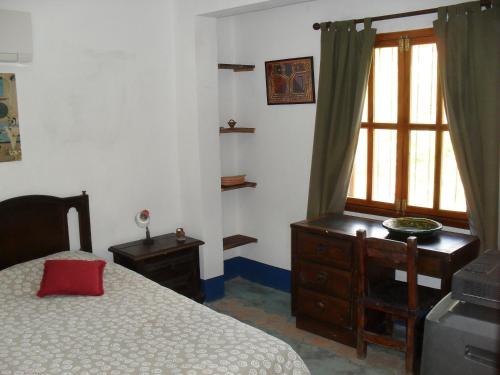 a bedroom with a bed and a dresser and a window at Posada la Arcadia in Pedro Gonzalez