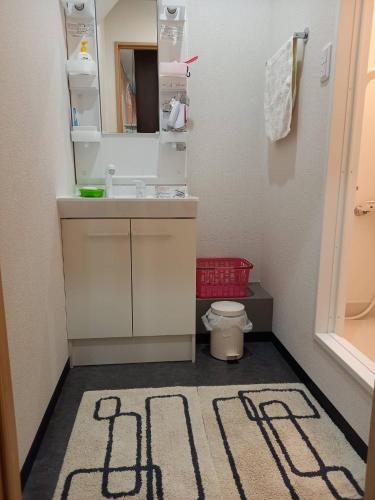 a bathroom with a sink and a mirror at FukuokaKoryou GuestHouse in Fukuoka