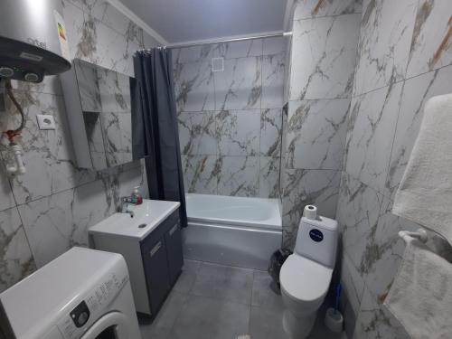 a bathroom with a sink and a toilet and a tub at Апартаменты на Кенесары 83 in Kokshetau