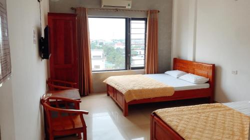 a small room with two beds and a window at Hai Hoa Hotel in Cửa Lò