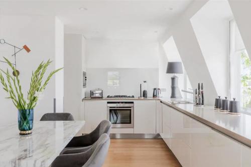 una cucina bianca con tavolo e sedie di Stunning Covent Garden DREAM COME TRUE Super Quiet HOTEL Alike HOME a Londra