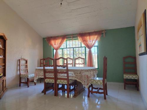 d'une salle à manger avec une table, des chaises et une fenêtre. dans l'établissement Casa de campo, Huasca Hidalgo, à Huasca de Ocampo