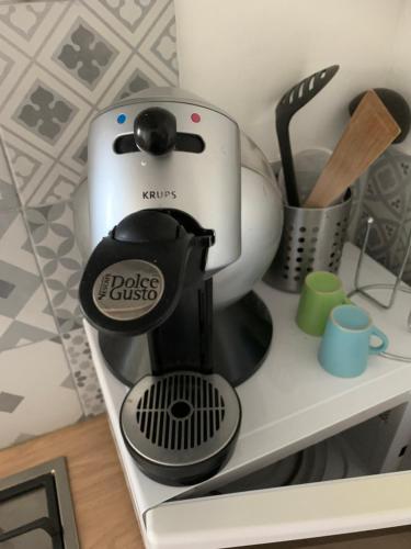 a black and white coffee maker sitting on a shelf at appartement dans maison basque in Mouguerre