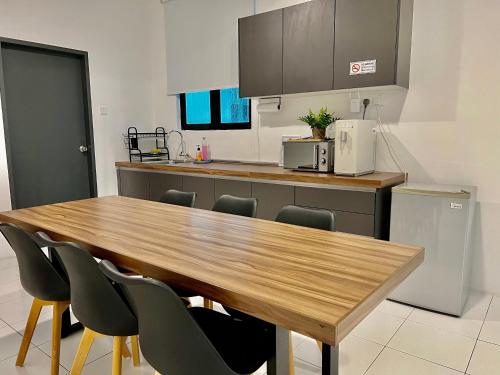 a kitchen with a wooden table and chairs at PadiViu Family Suite at Imperio Professional Suite, Alor Setar in Alor Setar