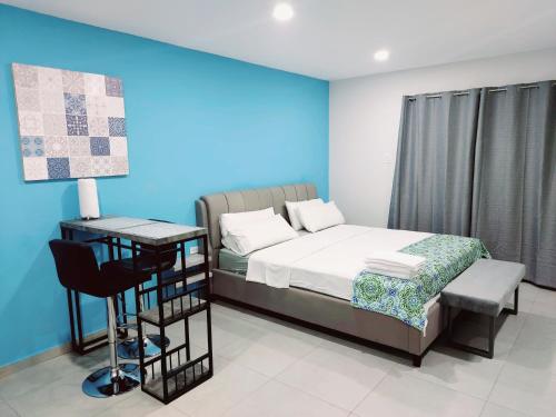 a bedroom with a bed and a desk with a chair at Apricity Suites Aruba in Noord