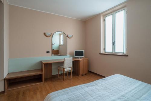 ヴァレッジョ・スル・ミンチョにあるAgriturismo San Francescoのベッドルーム(デスク、ベッド、鏡付)