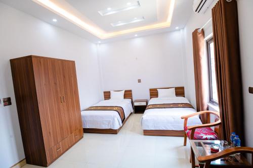 een slaapkamer met 2 bedden en een houten kast bij Hồng Ngọc Hotel in Lạng Sơn