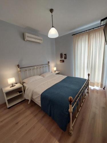 1 dormitorio con 1 cama grande con manta azul en Notos Guesthouse, en Monemvasia