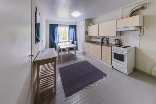 a kitchen with white cabinets and a table in it at YH Lappeenranta in Lappeenranta