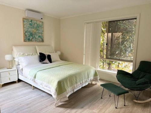 a bedroom with a bed and a chair and a window at Townhouse in Franklin in Harrison