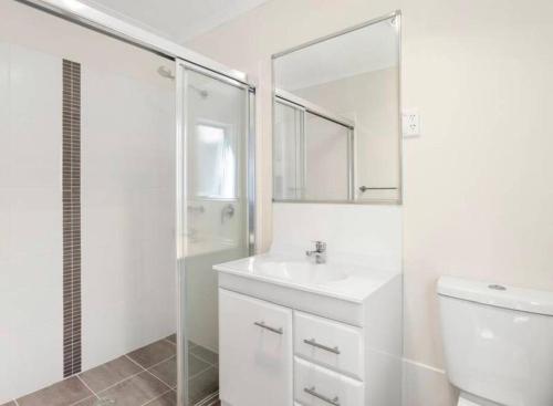 a white bathroom with a sink and a shower at Townhouse in Franklin in Harrison