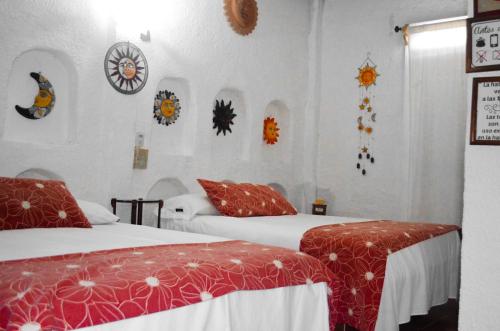 Habitación de hotel con 2 camas y decoración en las paredes en Posada Casa Antigua, en Tecolutla