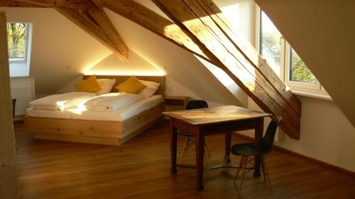 ein Schlafzimmer mit einem Bett und einem Tisch im Dachgeschoss in der Unterkunft Hotel Burgmeier in Dachau