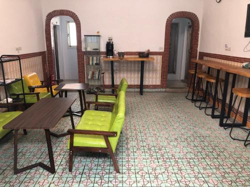 ein Zimmer mit grünen Stühlen und Tischen in der Unterkunft 不倒翁輕旅 in Hsi-kuo-shan