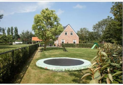a large circle in the grass in front of a house at Mooi, vrij gelegen vakantiehuis dichtbij zee en strand! in Aagtekerke