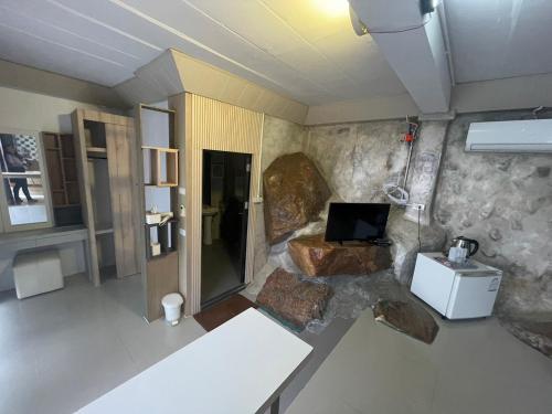 a room with a living room with a rock wall at ภูนางฟ้า Angel Hill in Ban Khlong Phai