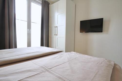 a bedroom with a bed and a tv on a wall at Ferienwohnung Strandperle im Haus Anna in Wangerooge