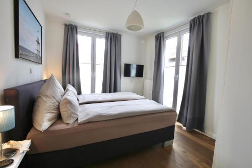 a bedroom with a bed and a large window at Ferienwohnung Strandperle im Haus Anna in Wangerooge