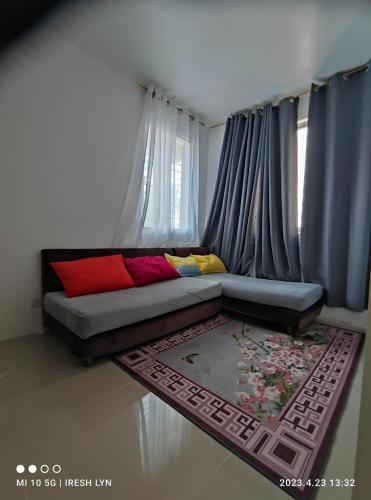 um sofá com almofadas coloridas numa sala de estar em iConnect Your Home Away From Home em Tagum