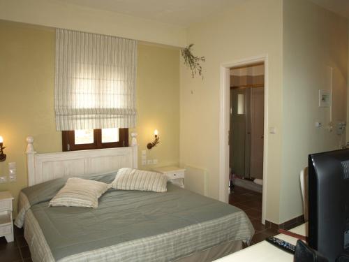a bedroom with a bed with two pillows and a window at Porto Mani Suites in Kyparissos