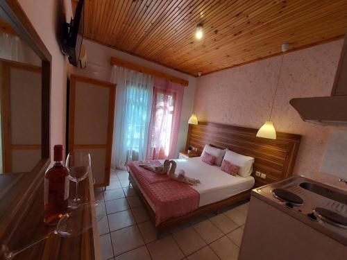 a small bedroom with a bed and a kitchen at Sun Helios Garden Aparthotel in Limenas