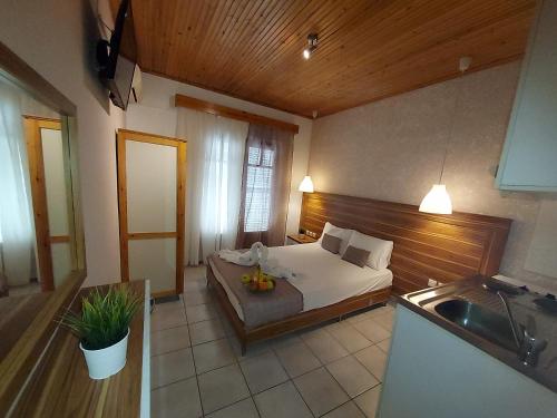 sypialnia z łóżkiem oraz kuchnia ze zlewem w obiekcie Sun Helios Garden Aparthotel w mieście Limenas