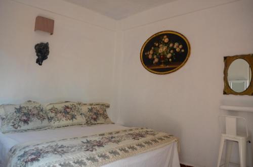 1 dormitorio con cama y espejo en la pared en Posada Casa Antigua, en Tecolutla
