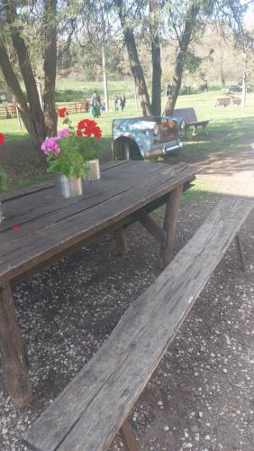 a wooden picnic table in a park with flowers at Camera da priscilla in Cesano