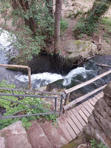 a staircase leading to a river with a waterfall at Camera da priscilla in Cesano