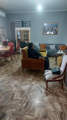a man sitting on a couch in a living room at Camera da priscilla in Cesano