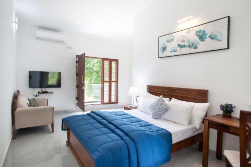 a bedroom with a blue blanket on a bed at StayVista at Ivory Hill Madikeri including breakfast 3 Bhk Villa in Madikeri