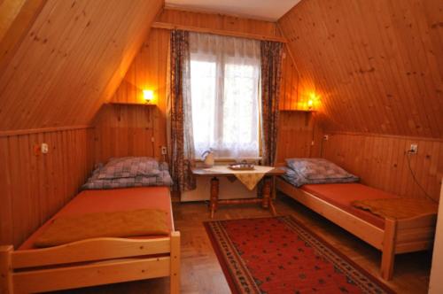 ザコパネにあるSfinksのベッド2台、窓、シンクが備わる客室です。