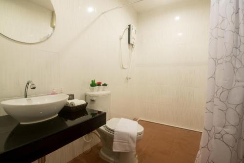 a white bathroom with a sink and a toilet at Green Leaf Hostel in Phuket