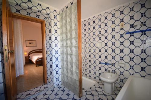 y baño con lavabo y paredes de azulejos azules y blancos. en Appartamento Santa Barbara, en Scarlino