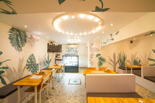 a restaurant with tables and chairs and plants painted on the walls at Hotel Searock in Visakhapatnam