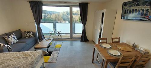 a living room with a couch and a table at Apartmán Na kraji lesa in Janov nad Nisou