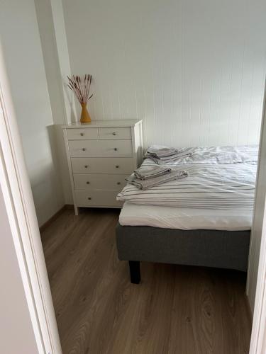 a bedroom with a bed and a dresser in it at Lofoten seaview in Ballstad