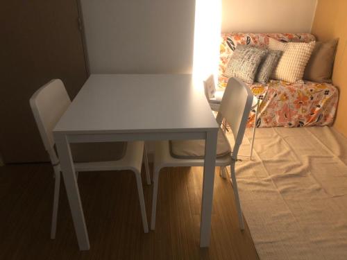 a white table and chairs in a room with a couch at Cozy Home 1 bedroom in Manila