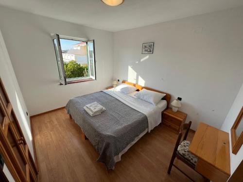 a bedroom with a bed and a window at Beachfront Lovro apartment in Šimuni