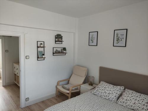 a bedroom with a bed and a chair and pictures on the wall at Mirador del Oja in Ezcaray