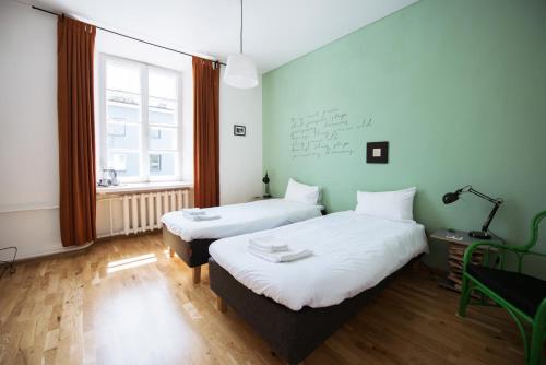 a room with two beds and a window at Rooms and Suites at Bookinn B&B in Vilnius