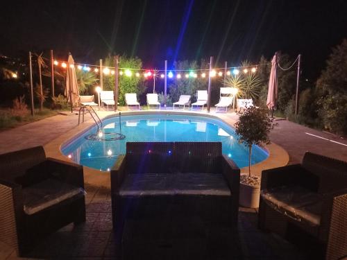a swimming pool at night with chairs and lights at Villa Laura Apartment in Giardini Naxos