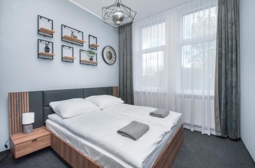 ein Schlafzimmer mit einem großen Bett und einem großen Fenster in der Unterkunft Apartamenty Zabrska 45 in Gliwice