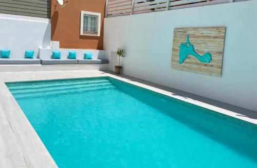 uma piscina com água azul numa casa em Boho Suites Formentera em Es Pujols