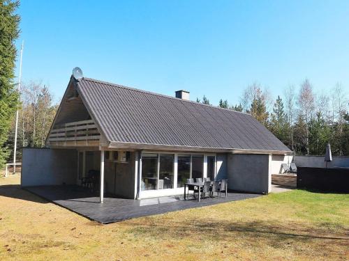 a house with a roof with a deck with a table at 6 person holiday home in H jslev in Højslev