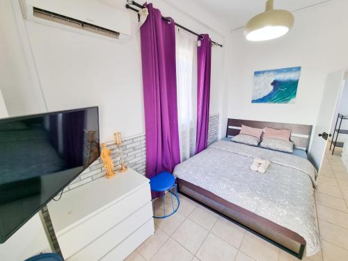 a bedroom with a bed and a flat screen tv at Aladdin's Hostel in Larnaka