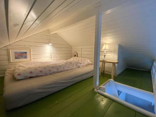 Lofotbua في Offersøya: غرفة نوم صغيرة مع سرير في العلية