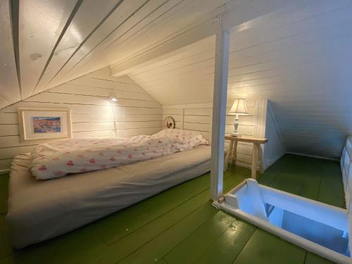 a small bedroom with a bed in a attic at Lofotbua in Offersøya
