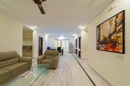 a living room with a couch and a painting on the wall at Luxury Suites by Athome in Kondapur
