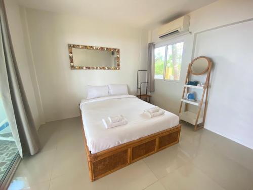 a bedroom with a bed and a mirror and a window at Issara Beach Resort in Sichon